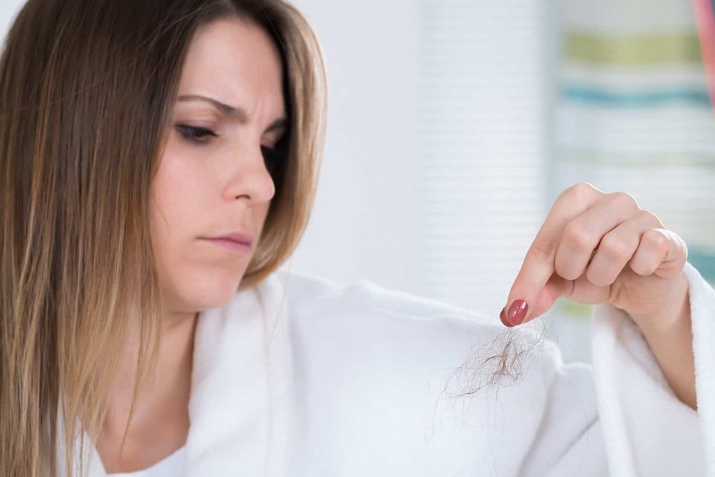 Mulher segurando fio cabelo
